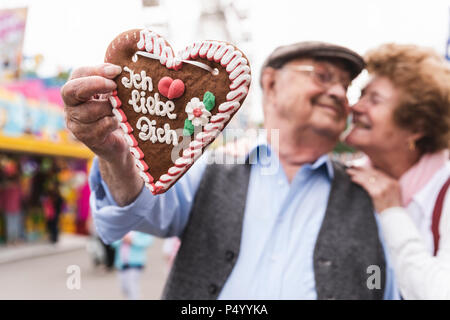 Die Hand des älteren Mann mit ingerbread Herz auf faire, close-up Stockfoto