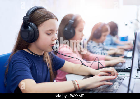 Schüler tragen Headsets und mit Laptops in der Schule Stockfoto