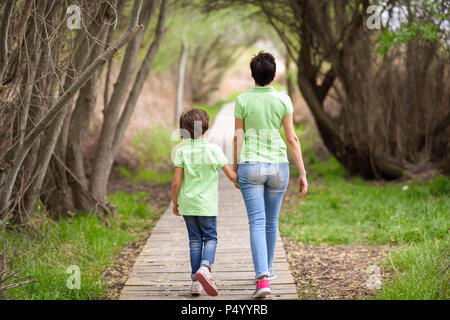 Hintere Ansicht von Mutter und Tochter gehen Hand in Hand am Boardwalk Stockfoto