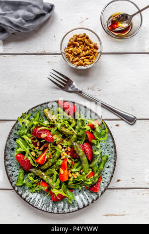 Salat von grünem Spargel, Rucola, Erdbeeren und Pinienkernen Stockfoto