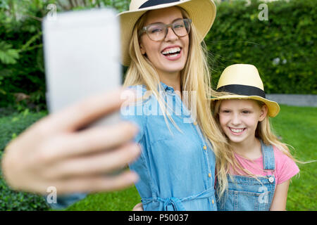 Glückliche Mutter und Tochter einen selfie im Garten Stockfoto