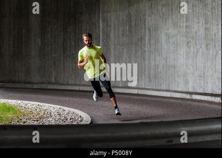 Mann laufen auf einer Straße in einer Kurve Stockfoto