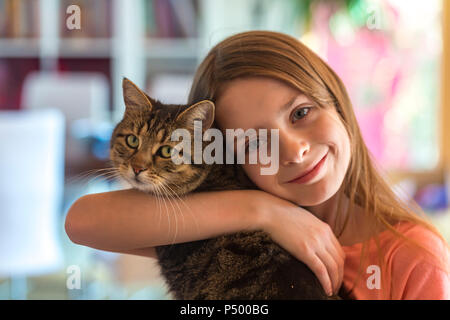 Portrait von lächelnden Mädchen mit ihrem Tabby cat Stockfoto