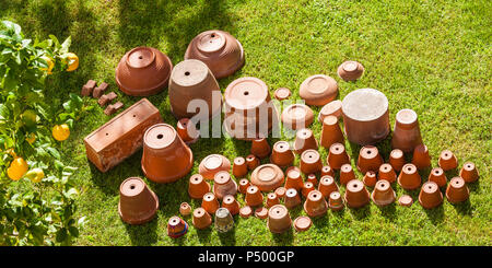 Leere Blumentöpfe auf den Kopf stehend auf Gras Stockfoto