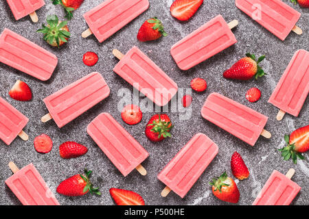 Selbstgemachte Erdbeer Eis am Stiel und Erdbeeren auf Marmor Stockfoto