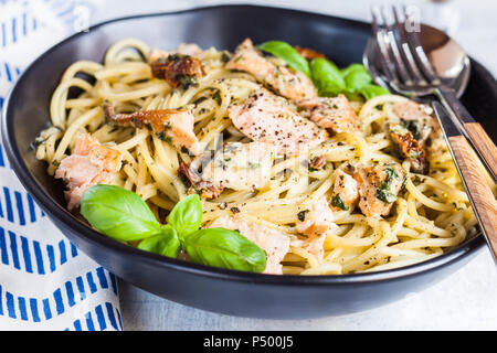 Spaghetti mit cremigem Spinat Soße, getrockneten Tomaten und Lachs Stockfoto