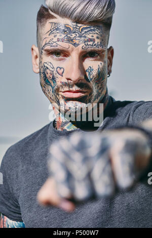 Portrait von tätowierten jungen Mann draußen ballte seine Faust Stockfoto