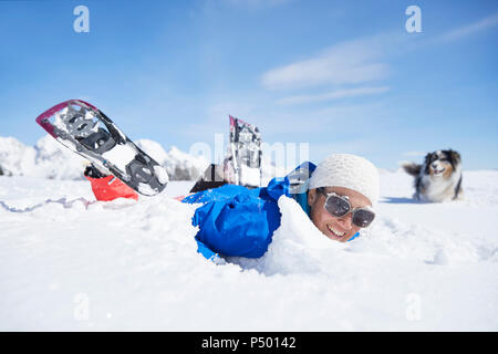 Österreich, Tirol, Schneeschuh Wanderer und Hund, Spaß im Schnee Stockfoto
