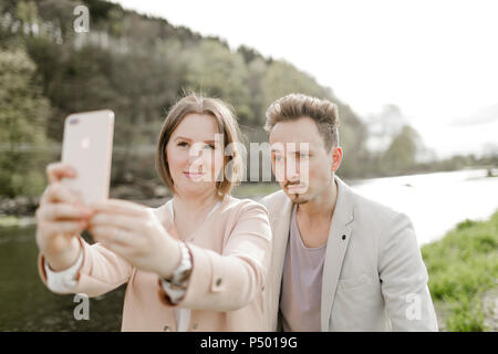 Porträt eines jungen Paares unter selfie mit Smartphone im Freien Stockfoto