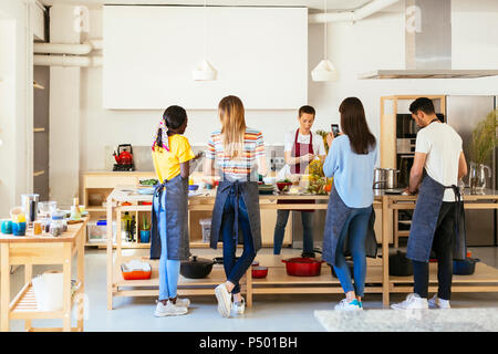 Freunde und Lehrer in einem kochworkshop Essen zubereiten Stockfoto