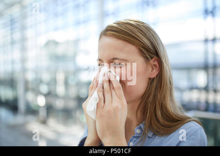 Junge Frau bläst Nase Stockfoto