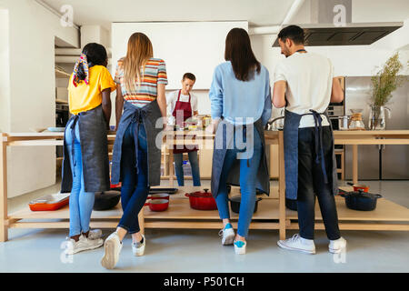 Freunde und Lehrer in einem kochworkshop Essen zubereiten Stockfoto