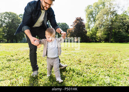 Vater, Sohn in einem Park spazieren zu gehen Stockfoto