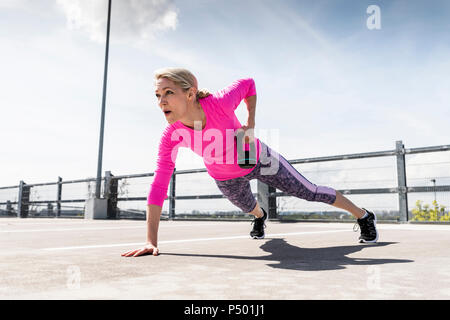 Frau Training mit Hanteln, einarmige Liegestütz Stockfoto