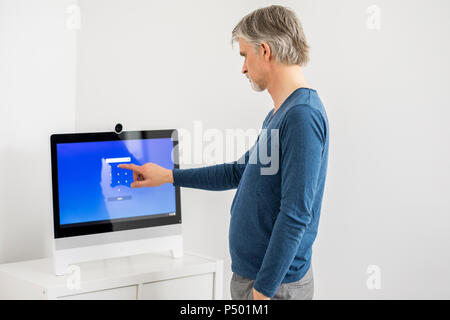 Geschäftsmann Eingabe PIN-Code auf dem Touchscreen Stockfoto