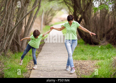 Mutter und Tochter gehen Hand in Hand am Boardwalk Stockfoto