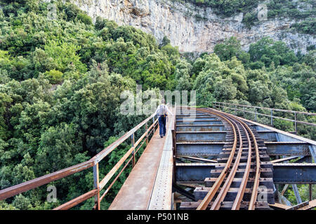 Griechenland, Pilion, Milies, Rückansicht der Mann auf der Brücke entlang der Schienen der Schmalspurbahn Stockfoto