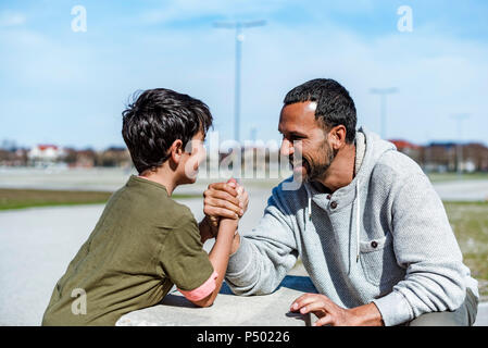 Vater und Sohn Armdrücken im Freien Stockfoto