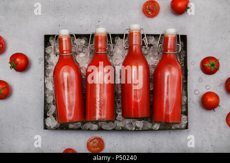 Zeile vier ice-gekühlte Bügelverschlussflaschen mit hausgemachten Tomatensaft Stockfoto