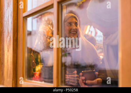 Junges Paar trinken Glühwein am Weihnachtsmarkt Stockfoto