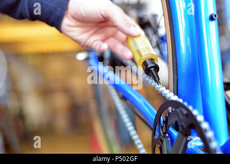 Fahrradmechaniker Fahrrad Kette schmieren Stockfoto