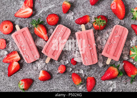 Vier hausgemachtes Erdbeer Eis am Stiel, Eis und Erdbeeren auf Marmor Stockfoto