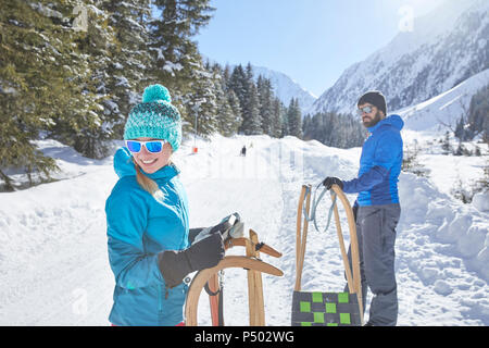 Paar mit Schlitten in der verschneiten Landschaft Stockfoto