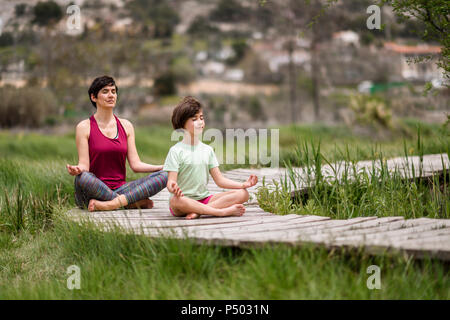 Mutter und Tochter Yoga am Boardwalk Stockfoto