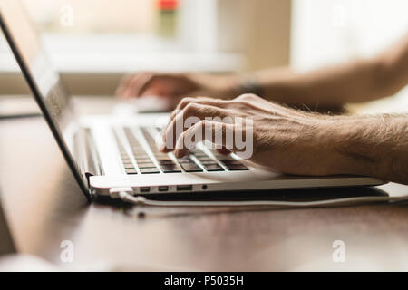 Des Menschen Hand auf Tastatur von Notebook, Teilansicht Stockfoto