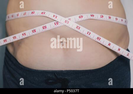 Nahaufnahme des menschlichen Körpers und fetten Körper, Fett Körper Teil der Bauch oder Bauch, Übergewicht von Personen oder Übergewicht mit Maßband. Stockfoto