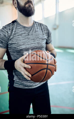 Mann spielt Basketball, Innen Stockfoto