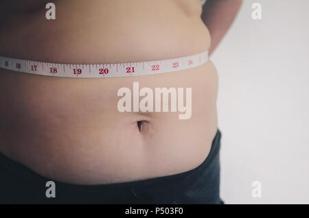 Nahaufnahme des menschlichen Körpers und fetten Körper, Fett Körper Teil der Bauch oder Bauch, Übergewicht von Personen oder Übergewicht mit Maßband. Stockfoto