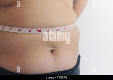 Nahaufnahme des menschlichen Körpers und fetten Körper, Fett Körper Teil der Bauch oder Bauch, Übergewicht von Personen oder Übergewicht mit Maßband. Stockfoto