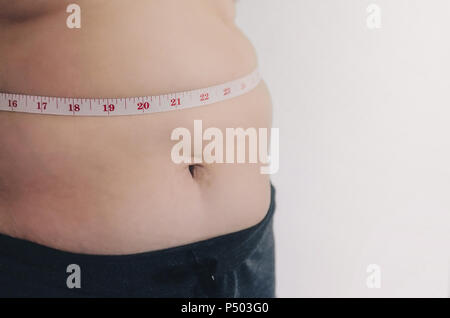 Nahaufnahme des menschlichen Körpers und fetten Körper, Fett Körper Teil der Bauch oder Bauch, Übergewicht von Personen oder Übergewicht mit Maßband. Stockfoto