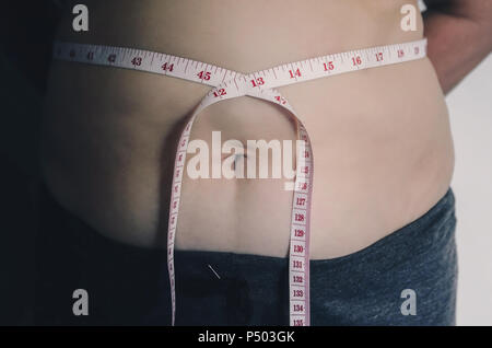 Nahaufnahme des menschlichen Körpers und fetten Körper, Fett Körper Teil der Bauch oder Bauch, Übergewicht von Personen oder Übergewicht mit Maßband. Stockfoto