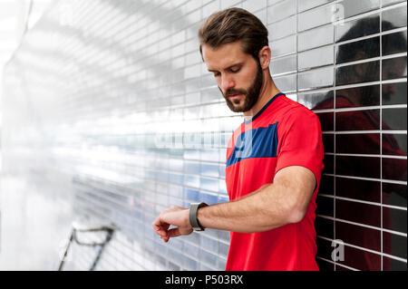 Mensch, der hatte eine Pause von der laufenden Kontrolle der Zeit auf einem smartwatch Stockfoto