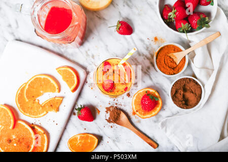 Erdbeeren und Orangen Smoothie mit Kurkuma und Zimt auf Marmor Stockfoto