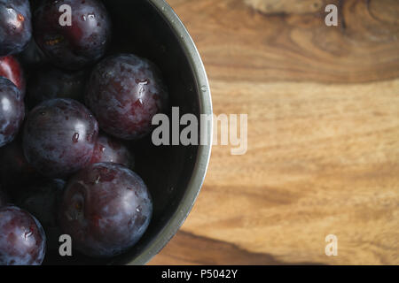 Frisch große Pflaumen in einer Schale auf Holz Tisch gewaschen, flachen Fokus Stockfoto