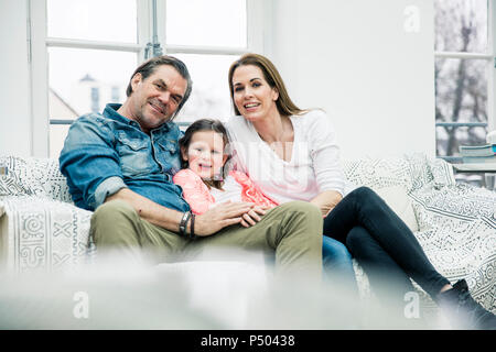 Portrait der glücklichen Familie sitzt auf der Couch Stockfoto
