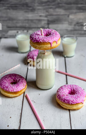 Rosa Donuts und Flasche Milch Stockfoto