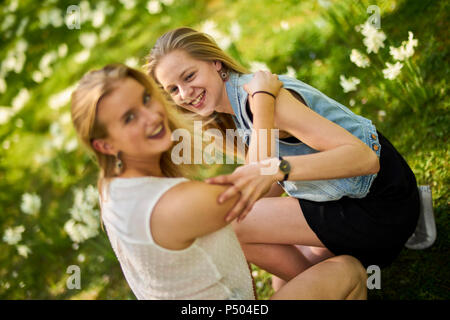 Zwei Freunde, die zusammen Entspannen auf Blumenwiese Stockfoto