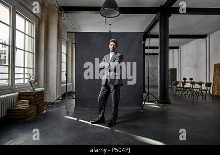 Portrait von Reifen Geschäftsmann vor schwarzem Hintergrund auf dem Dachboden Stockfoto