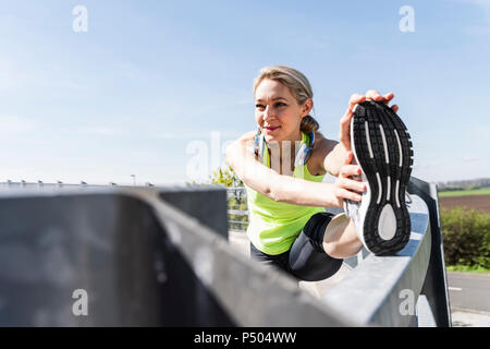 Frau Joggen in der Stadt, eine Pause, Stretching Stockfoto