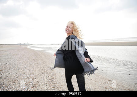 Niederlande, Porträt der blonde junge Frau, die auf den Strand Stockfoto