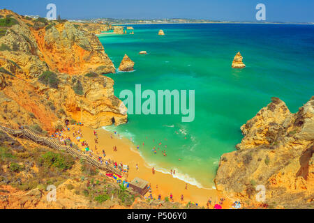 Luftaufnahme von Praia do Camilo mit langen Schritten in der Algarve, Portugal, Europa. Türkis und klare Wasser zwischen den Felsformationen und Säulen auf die Bucht von Lagos. Sommer Urlaub, Atlantik. Stockfoto