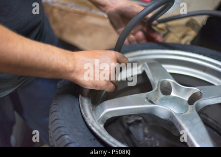 Nahaufnahme der Mechaniker in Reparatur Service Station Aufpumpen von Reifen. Stockfoto