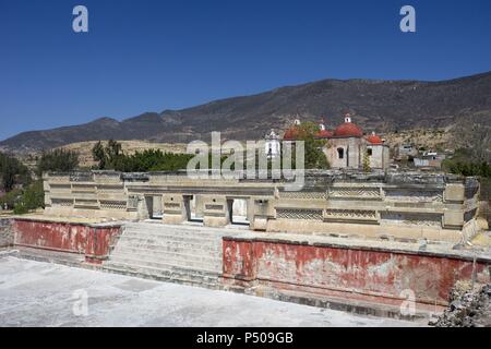 Mexiko. Mitla. Alte Mixtec-Zapotec zeremonielle Zentrum. Fassade der großen Halle der Spalten. Im Hintergrund, die katholische Kirche der Stadt. Oaxaca Staat. Stockfoto