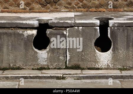 Ostia Antica. Latrine bei Domus Triclini, Sitz der Zunft der Bauherren. 2. Jahrhundert n. Chr. In der Nähe von Rom. Stockfoto