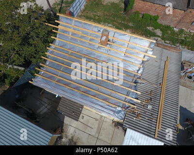 Slavjansk-auf-Kubani, Russland - 10. September 2017: Reparatur von dem Dach des Hauses. Feuchtigkeit Isolierung unter Metall. Stockfoto