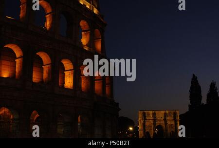 Italien. Rom. Das Kolosseum (Kolosseum) oder Flavischen Amphitheater. Elliptische Konstruktion gebaut aus Beton und Stein. 1. Jahrhundert A.C. Nächtliche Ansicht. Im Hintergrund, der Triumphbogen des Konstantin. Stockfoto